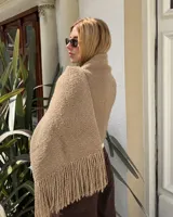 Pashmina de punto color beige con textura granulada y terminación de flecos largos en los extremos.