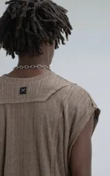 Sudadera sin mangas (tipo chaleco) de tejido liviano acanalado, color marrón chocolate, con calce amplio y recortes superpuestos que generan textura.