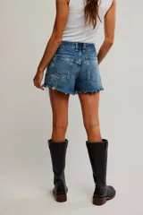 Short de denim de tiro medio y calce relajado, con cierre de cremallera y botón, cinco bolsillos, y detalles de desgastes y deshilachados.