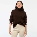 Suéter de punto color marrón, con cuello alto, mangas largas y diseño holgado.