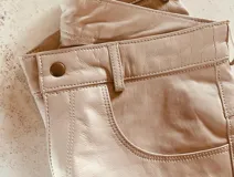 Pantalón slouchy de cuero ovino italiano color nude, corte mom fit con tiro semi alto y tajos inferiores.