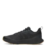 Championes de entrenamiento Under Armour modelo Charged Commit Tr 5, color gris oscuro con suela de goma en tono caramelo. Presentan diseño técnico con refuerzos laterales, logo de la marca en el lateral y lengüeta, y sistema de cordones para un ajuste seguro.