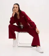 Pantalón deportivo de corte recto, confeccionado en tejido de microfibra color bordó. Presenta cintura elástica con cordón ajustable, bolsillos delanteros embutidos y detalle de bordado discreto en la pierna.