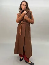 Tapado largo color marrón de lana merino afieltrada, con cuello grande, lazos para ajustar en la cintura, bolsillos laterales y puños calados.