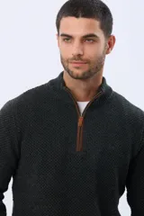 Buzo tejido de punto grueso en color azul marino, con cuello alto y cierre frontal parcial. Presenta detalles en gamuza en la zona del cierre y una textura en relieve en toda la prenda.