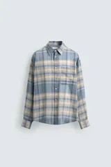 Camisa de corte relajado confeccionada en tejido ligero de algodón, con diseño de cuadros en tonos azules y beige. Presenta cuello solapa, cierre frontal de botones, manga larga con puño abotonado y un bolsillo en el pecho.