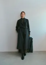 Abrigo largo estilo batín en color verde oscuro, confeccionado con mezcla de lana, con solapas amplias, bolsillos laterales y cinturón ajustable del mismo tejido.