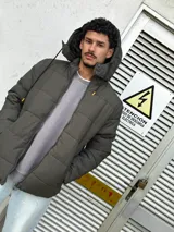 Campera puffer verde oscuro con capucha y cierre frontal.