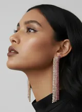 Caravanas largas con múltiples tiras colgantes de piedras brillantes en degradado de colores blanco, rosado y fucsia.