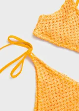 Top de bikini con diseño triangular confeccionado en tejido de crochet color amarillo, con forro interior y breteles finos.
