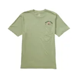 Remera de manga corta Volcom, color verde oliva, con cuello redondo y bolsillo frontal. Presenta un estampado serigráfico sobre el bolsillo con el logo de la marca y un diseño de montañas.