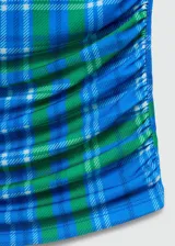 Top crop sin mangas con cuello redondo y diseño entallado con detalles drapeados. Presenta un estampado de cuadros en tonos azules y verdes.