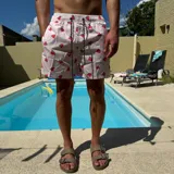 Short de baño negro con estampado de rodajas de naranja, cintura elástica con cordón ajustable y logo circular en el ruedo.