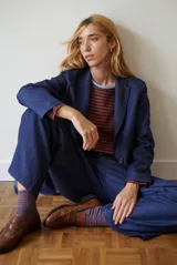 Blazer de corte sastrero confeccionado en tela tipo jean azul, con solapas clásicas, cierre frontal con botones y estructura entallada.