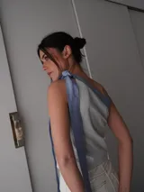 Top celeste y blanco a rayas verticales, con un solo hombro y lazo ancho en color celeste.