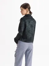 Camisa de jacquard con diseño de flores sutiles, color blanco, con cuello amplio de puntas marcadas, mangas largas con puños y cierre frontal con botones.