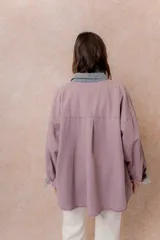 Camisa de denim color verde menta con calce relajado, cuello clásico, cierre frontal con broches metálicos, mangas largas y bolsillo aplicado en el pecho, con detalles en tono gris azulado a contraste en cuello, cartera, bolsillo y puños.