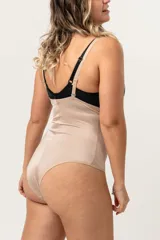 Faja abdominal color piel, cavada, reforzada en la zona abdominal, confeccionada en lycra. De contención media, cola bikini, con breteles desmontables regulables y broche en la entrepierna con fundillo de algodón.