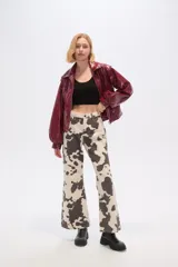 Chaqueta corta de cuero sintético negro con cuello camisero, cierre frontal con cremallera, bolsillos laterales y mangas largas abullonadas.