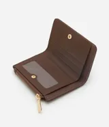 Billetera compacta Satinato de cuero sintético color marrón, con diseño tipo sobre. Cuenta con cierre metálico, botón a presión, monedero integrado y detalle de chapa triangular dorada con el logo de la marca en el frente.