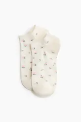 Pack de siete soquetes de color blanco con delicados estampados florales dispersos en tonos rosados y azules.