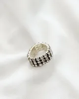 Anillo plateado con tres hileras de strass, de largo ajustable y 10mm de alto.