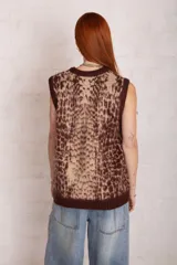 Chaleco de punto con estampado animal print en tonos beige y marrón, con cuello en V y ribetes en marrón oscuro.