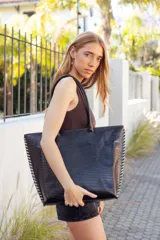 Bolso tote grande de cuero negro con textura croco, doble asa de hombro y costuras laterales en contraste color crudo.