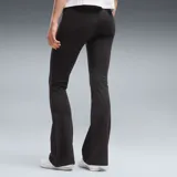 Calza deportiva Puma de corte flared (acampanado) en color marrón oscuro, con cintura alta y logo de la marca estampado en blanco en la pierna izquierda.
