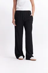 Pantalón de vestir de tiro alto, color crema, con textura crepe arrugada y pierna ancha y fluida. Presenta cintura elástica.