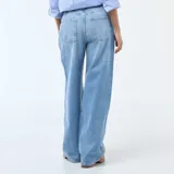 Pantalón de jean estilo baggy con tiro bajo, corte amplio y pierna recta. Presenta un lavado azul medio con costuras laterales destacadas en tono claro.