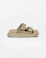 Sandalias de dos tiras con ajuste de velcro, confeccionadas en gamuza color beige. Presentan suela de plataforma con diseño texturizado y logo de la marca grabado en la tira superior.