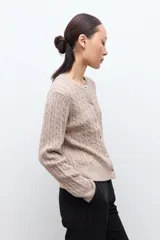 Cardigan de punto con textura de ochos, color tostado melange, con cuello redondo y cierre frontal de botones.