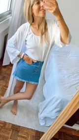 Minifalda de jean azul con botones frontales y ruedo desflecado.