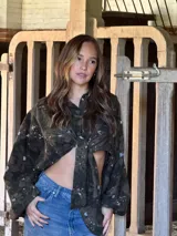 Camisa de lino con estampado orgánico en tonos oscuros, de silueta relajada, mangas amplias y detalle de nudo frontal.