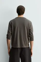 Camiseta de manga larga con cuello redondo y cierre frontal de tres botones, confeccionada en tejido de mezcla de algodón con corte relajado.