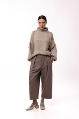 Sweater de punto grueso con cuello alto, diseño de hombros caídos y mangas amplias con puños acanalados.