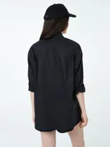 Conjunto compuesto por una camisa de manga larga con botones frontales y un short con cintura elástica y cordón ajustable, ambos en color negro.