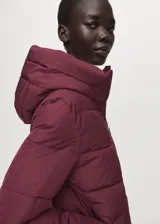 Campera puffer color bordó con capucha, cierre frontal con cremallera y diseño acolchado con costuras horizontales.