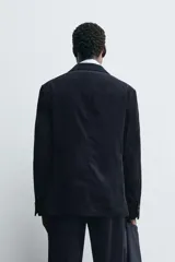Blazer de corte relajado confeccionado en pana de algodón. Presenta cuello con solapas de muesca, cierre frontal con botones, bolsillo de vivo en el pecho y bolsillos con solapa en la cadera. Incluye aberturas en la espalda y puños con botones.