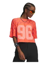 Remera Under Armour estilo deportivo de manga corta, color salmón, con diseño de cuadros en la parte superior y gran número "96" estampado en el frente. Confeccionada en mezcla de algodón y poliéster.