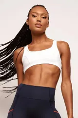 Top deportivo negro con tirantes medianos y espalda baja, confeccionado en poliamida de alto rendimiento. Cuenta con inscripciones estampadas en el frente con la frase "Performance Pro" y detalles gráficos.