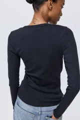 Remera entallada de manga larga con cuello redondo, confeccionada en tejido de punto.