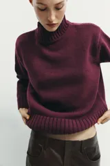 Jersey de punto liso con cuello subido, manga larga y acabados en rib en puños, cuello y ruedo.
