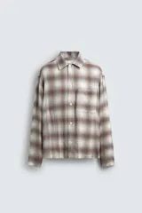 Camisa relaxed fit de cuadros en tonos marrón, beige y gris, confeccionada en tejido con mezcla de viscosa. Cuenta con cuello solapa, manga larga, bolsillo plastrón en el pecho, bajo con aberturas laterales y cierre frontal de botonadura.