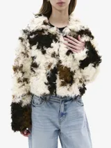 Chaqueta corta de piel sintética con estampado en tonos blanco, marrón y negro, con cierre frontal con gancho metálico.