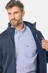 Campera de felpa azul con interior de polar, cuello alto y cierre frontal. Cuenta con bolsillos laterales con cierre y detalles en cuero sintético.