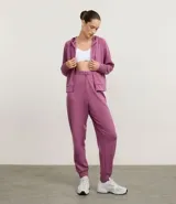 Campera deportiva con cierre frontal de cremallera, capucha ajustable con cordones, mangas largas con puños ajustados y bolsillo tipo canguro. Presenta un diseño con sisa raglán y recorte en la espalda.