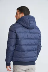 Campera puffer Mistral de hombre, color azul marino con cierre frontal y detalles en color rojo. Cuenta con capucha, puños elásticos y logo estampado en el pecho.