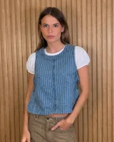 Chaleco de denim azul con diseño a rayas verticales, cuello redondo y cierre frontal.